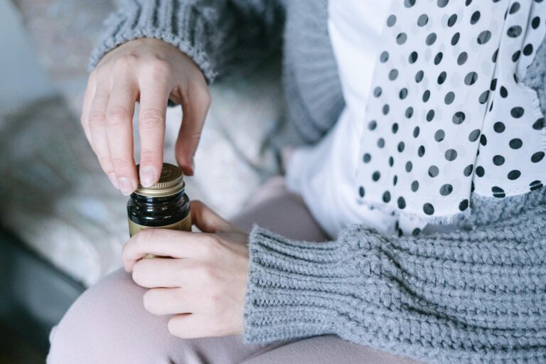 A close-up of hands opening a medicine bottle, emphasizing healthcare and recovery.
